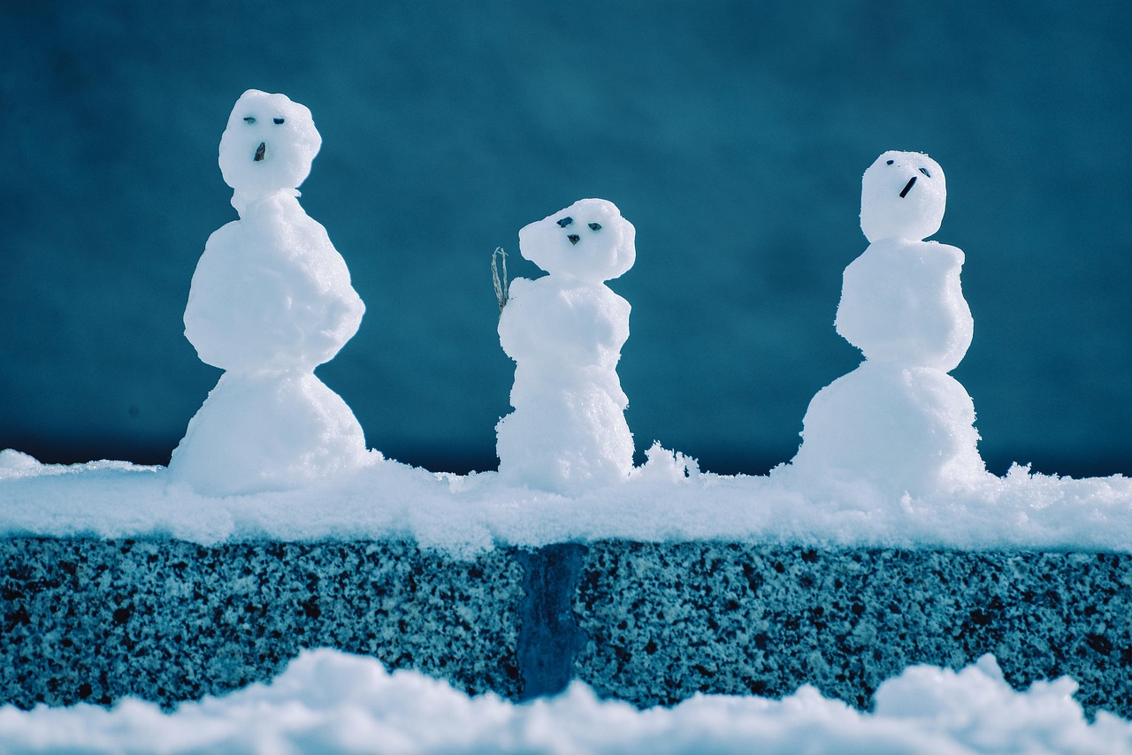 Family building a snowman near a snowy Lake Tahoe cabin