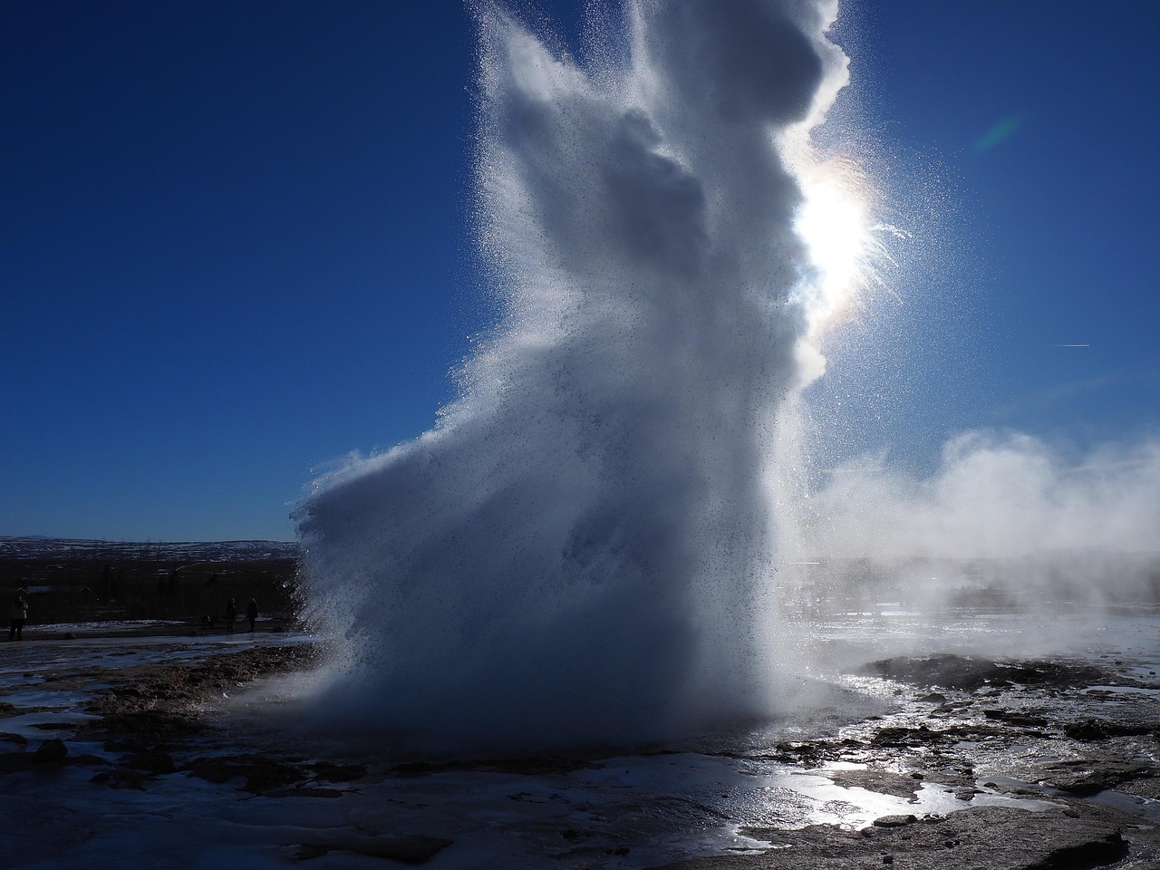 Tourists viewing Old Faithful geyser eruption