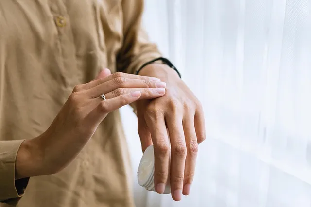 Woman applying topical cream in a well-lit bathroom