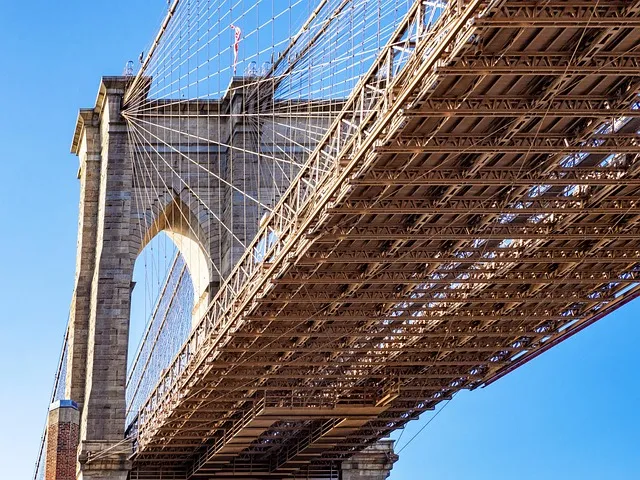People walking across Brooklyn Bridge on a crisp fall day