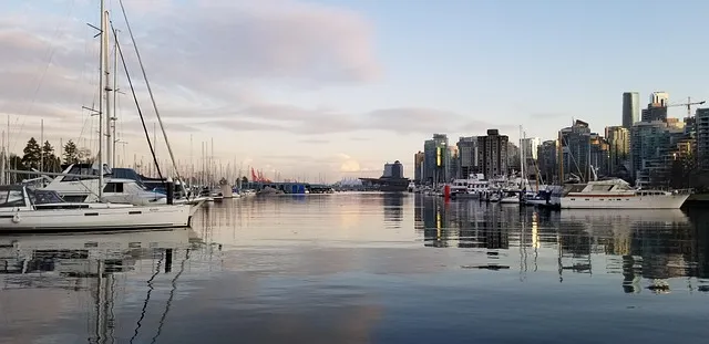 People biking along the Stanley Park seawall in Vancouver with city skyline views